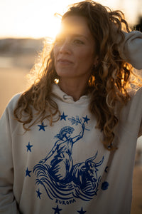 Ankerherz Hoodie EUROPA ONE LOVE Ivory Garment Dye, blauer Siebdruck Europa auf Zeus-Stier mit zwölf Sternen von Dani Garreton, Unisex Frontansicht